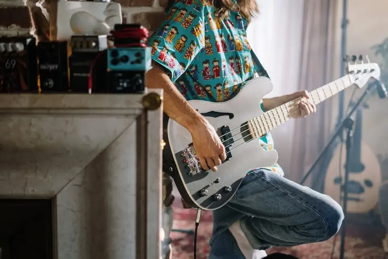 Woman in Red Blue and White Plaid Button Up Shirt Playing Electric Guitar