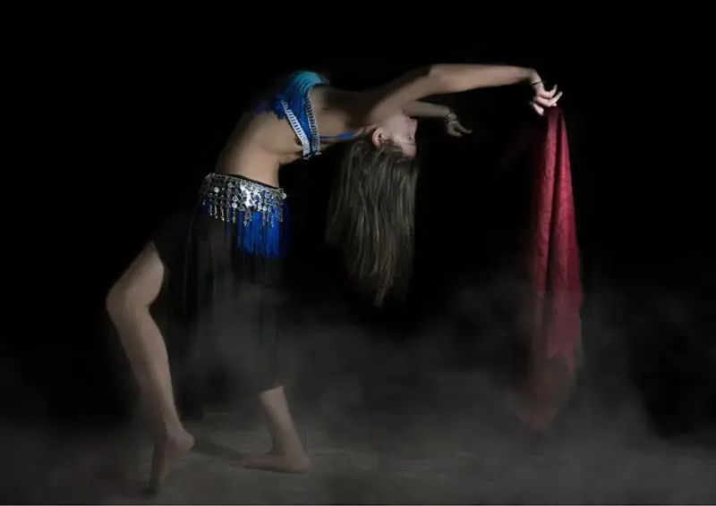 A woman in a belly dance costume is dancing